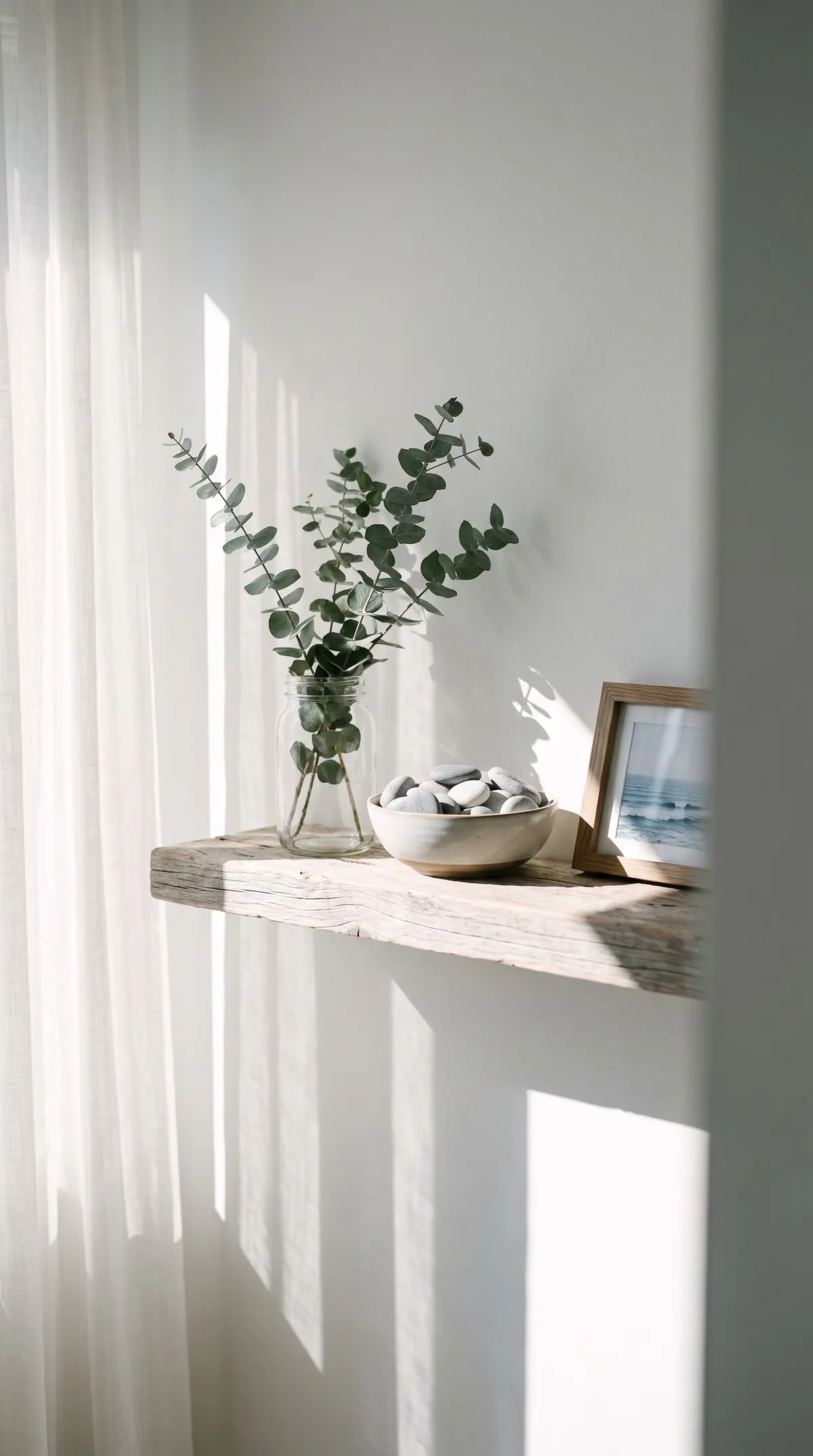 Driftwood shelf with eucalyptus, sea stones and an ocean print